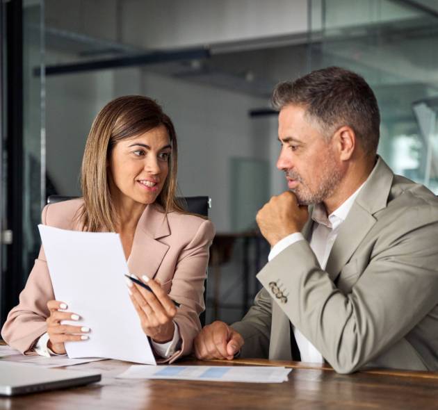 Female lawyer attorney or bank manager consulting male client holding papers during legal advice. Two business executives discussing financial accounting documents report working at meeting in office.